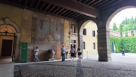 Giardino-Giusti-gardens-in-Verona-with-visitors-and-fresco-painted-on-the-walls-of-the-entrance-area