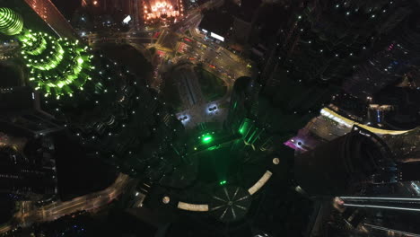 Aerial-view-rotating-above-the-skydeck-of-the-Petronas-Twin-Towers,-night-in-KLCC