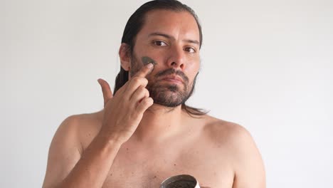 Latin-man-taking-care-of-his-face-with-clay-mask