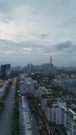 Aerial-Evening-View-of-Ho-Chi-Minh-City-Skyline-from-Sala,-a-modern-luxurious-development-with-park-and-lake-near-the-Saigon-River