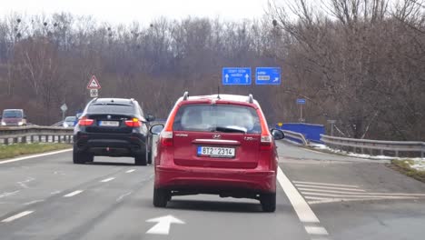 Coche-Familiar-Hyundai-I30-Cw-Rojo-En-La-Carretera,-Vista-Trasera-Con-Cámara-Lenta