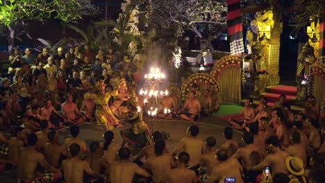 Kecak-Fire-Dance-at-Night-in-Bali---Princess-Sita,-Rama's-wife-Dancing-around-Big-Burning-Candlesticks-encircled-by-group-of-singing-men