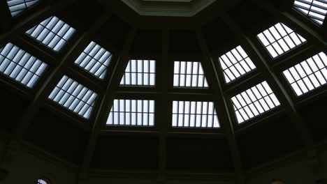 Tilt-down-shot-of-the-grand-interior-of-The-Dome-La-Trobe-Reading-Room-at-the-State-Library-Victoria-in-Melbourne,-octagonal-building-with-extensive-bookshelves,-creating-a-serene-study-environment