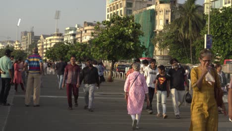 Diverse-crowd-of-people-walking-at-Marine-Drive-beach-promenade-in-the-evening