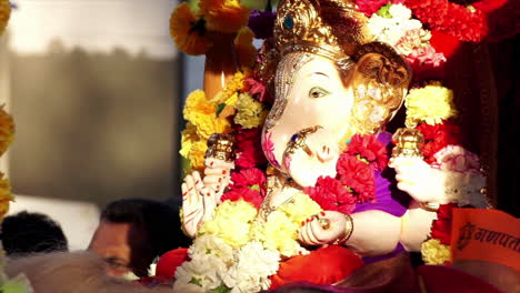 Una-Estatua-Murti-De-La-Deidad-Hindú,-Ganesh-Está-Adornada-Con-Flores-Y-Los-Celebrantes-La-Llevan-En-Procesión