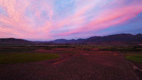 Sunset-to-twilight-over-countryside-fields-and-mountains-in-the-high,-Utah-desert---aerial-hyper-lapse