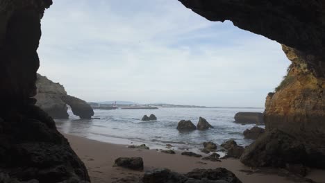 Scenic-view-of-Praia-dos-Estudantes-in-Lagos,-Portugal,-from-a-rocky-beach-cave
