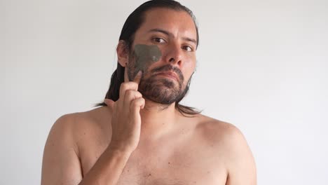 bearded-and-mature-man-finishing-putting-on-facial-mask
