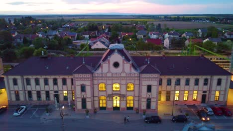 Drone-Vespertino-Descendiendo-Sobre-La-Entrada-Del-Edificio-De-La-Estación-De-Tren-De-Körmend