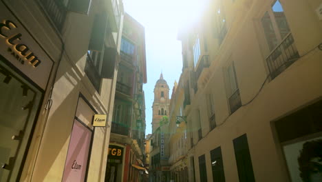 Sunny-street-in-Malaga's-city-center-with-a-view-of-historic-buildings-and-the-cathedral-in-the-background