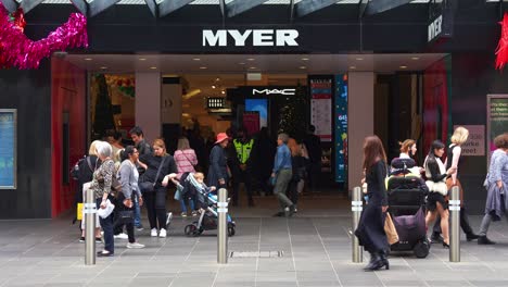 Myer's-Melbourne-flagship-store-on-Bourke-Street-Mall-with-pedestrians-strolling-by,-showcasing-the-bustling-shopping-hub-in-central-business-district,-captured-in-slow-motion