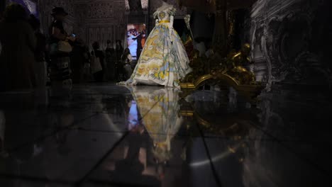 Un-Vestido-De-Fiesta-Sobre-Un-Maniquí-Se-Exhibe-En-Una-Sala-Ornamentada-De-Un-Museo-O-Exposición.