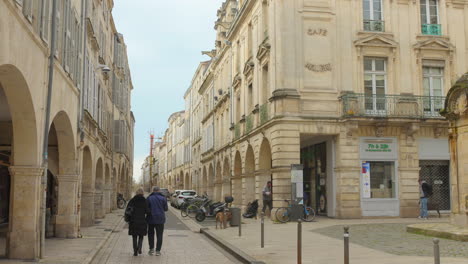 Shot-of-historic-street-of-La-Rochelle,-France-with-visitors-and-locals-trolling