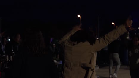 Slow-motion-shot-of-guests-dancing-at-a-outside-event-with-their-hands-in-the-air