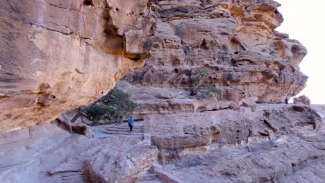 Turista-Caminando-Por-El-Sendero-Secreto-Del-Acantilado-A-Través-De-Montañas-Hacia-La-Antigua-Ciudad-De-Petra-En-Jordania