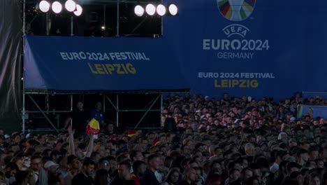 A-large-crowd-gathers-for-the-UEFA-Euro-2024-Festival-in-Leipzig,-Germany-at-night