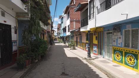 View-of-a-narrow-colorful-street-in-Guatape,-Colombia,-decorated-street,-colonial