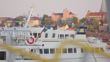 Stockholm-public-ferry-water-transport-pulls-in-to-harbour,-telephoto-static