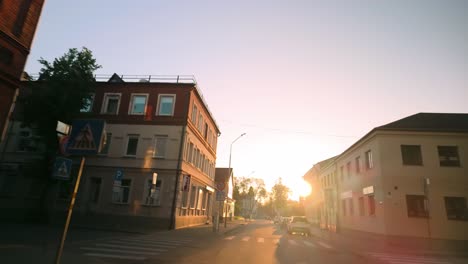 Eine-Morgendliche-Fahrt-Durch-Die-Leeren-Straßen-Einer-Baltischen-Innenstadt,-Beleuchtet-Vom-Sanften-Licht-Des-Sonnenaufgangs