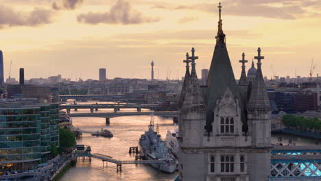 Telephoto-aerial-past-Tower-Bridge-over-Thames-at-sunset-and-London-cityscape