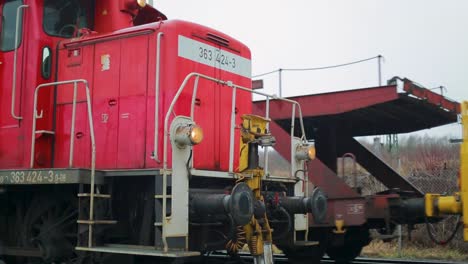 Red-Deutsche-Bahn-locomotive-and-yellow-maintenance-train-on-tracks-during-daylight