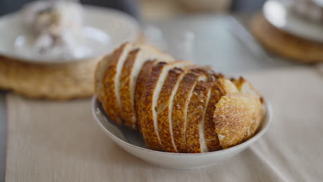 Geschnittenes-Sauerteigbrot-In-Einer-Weißen-Schüssel-Auf-Einem-Tischläufer