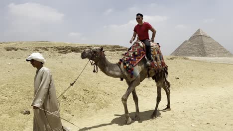 Los-Turistas-Se-Mueven-Por-Las-Pirámides-Egipcias-En-Camellos.