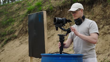 Cameraman-prepare-electronic-devices-on-blue-barrel-at-Olesko-shooting-range