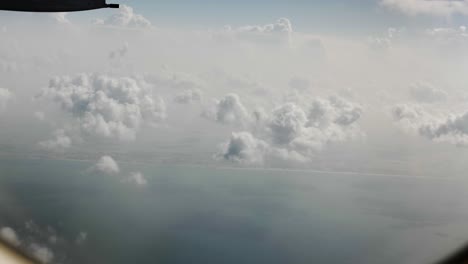 Aerial-view-from-airplane-of-clouds,-ocean,-cloudy-sky-over-Dubai