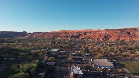 Drone-En-órbita-Disparado-Sobre-El-Centro-De-Moab,-Utah-Al-Atardecer-O-Al-Amanecer.