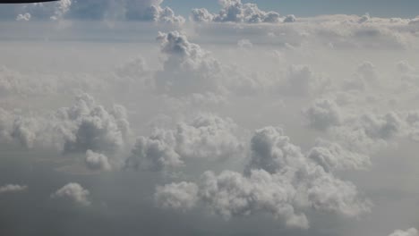 Aerial-view-from-airplane-of-clouds,-ocean,-cloudy-sky-over-Dubai