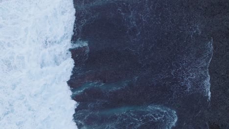 Drone-De-Arriba-Hacia-Abajo-De-La-Acción-De-Las-Olas-Durante-La-Marea-Baja-Sobre-Arrecifes-De-Coral-Y-Rocas-En-La-Playa-De-Nyang-Nyang,-Bali,-Uluwatu,-Indonesia