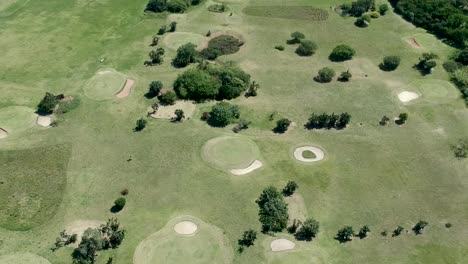 Aerial-footage-of-a-drone-moving-over-a-road-and-then-a-golf-course