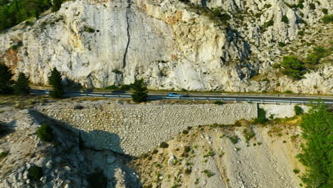 Aerial-view-following-a-car-on-a-mountain-road-at-the-Makarska-riviera,-Croatia