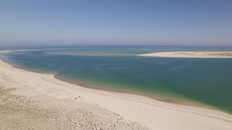 Ruhiger,-Friedlicher-Sandstrand-Mit-Weitläufigen-Dünen-Und-Geschütztem,-Ruhigem-Wasser