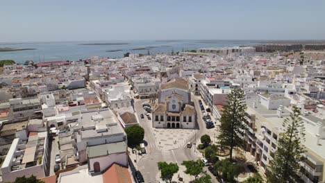 Church-of-Our-Lady-of-Rosario-in-Olhao-Portugal,-aerial-establishing-orbit-on-sunny-day