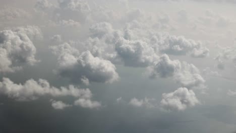 Aerial-view-from-airplane-of-clouds,-ocean,-cloudy-sky-over-Dubai