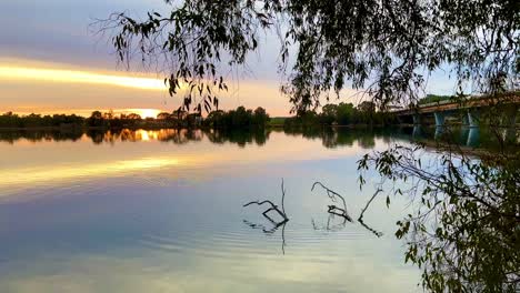 Amanecer-En-El-Río-Swan-De-Perth-Con-árboles-De-Goma-Que-Sobresalen-Y-El-Puente-Windan,-Washington