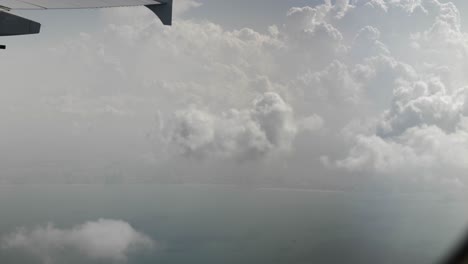 Aerial-view-from-airplane-of-clouds,-ocean,-cloudy-sky-over-Dubai