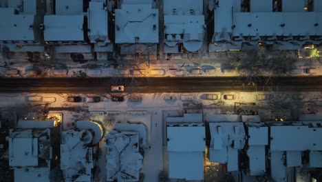 Car-on-road-lighting-by-lantern-during-snowy-winter-day-in-small-american-town