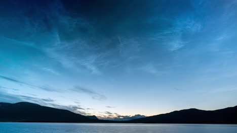 Timelapse-of-noctilucent-clouds-moving-slowly-in-the-sky-over-mountain-lake-in-Norway