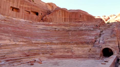 Nabataean-Petra-Theater-nestled-amongst-red-sandstone-rock-cliffs-within-the-city-of-Petra-in-Jordan