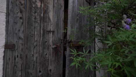 Rusty-Key-Locks-the-Grand-Gate-of-a-Stone-House-in-a-Balkan-Village,-Symbolizing-Mass-Emigration-from-Homeland