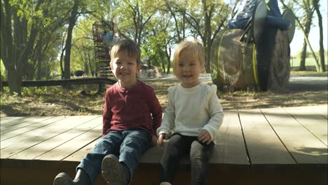 Happy-little-boy-and-girl,-brother-and-sister-smiling-at-halloween-pumpkin-patch-in-slow-motion