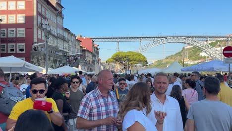 People-strolled-on-the-street-with-plastic-hammers-and-lightly-pounding-their-heads-during-the-celebration-of-São-João-do-Porto,-Portugal