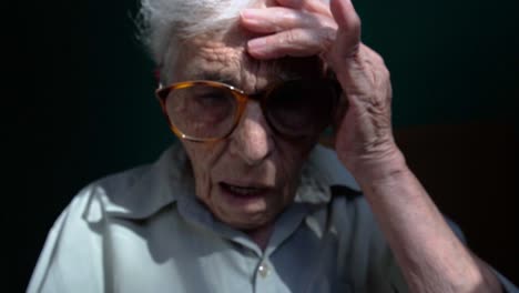 An-elderly-lady-wearing-glasses-uses-a-yellow-smartphone,-focusing-intently-on-the-screen