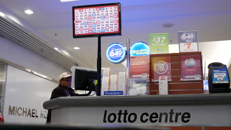 The-motion-of-a-man-buying-lottery-tickets-inside-a-mall-lottery-ticket-retailer-tooth