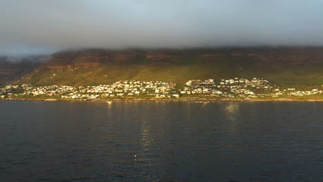 Möwe-Fliegt-In-Kapstadt,-Simonstown-Im-Hintergrund