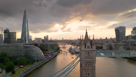 Sunset-aerial-trucking-view-of-iconic-Tower-Bridge-in-London-over-River-Thames