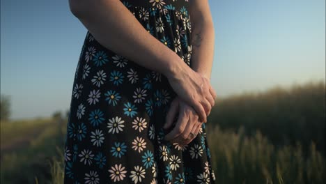 Young-woman-on-dirty-country,-road-enjoying-the-calm,-peaceful-and-serene-summer-sunset-with-light-shining-on-her-hair-during-golden-hour-in-cinematic-slow-motion